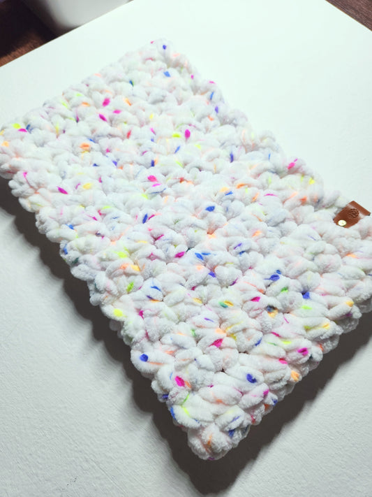 Textured white fabric with colorful sprinkles on a white surface