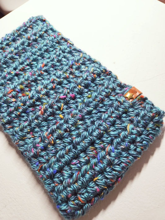 Blue knitted pouch with colorful speckles on a white background
