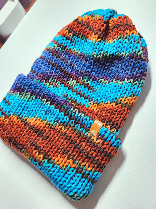 Colorful knitted beanie with a brand logo on a white surface
