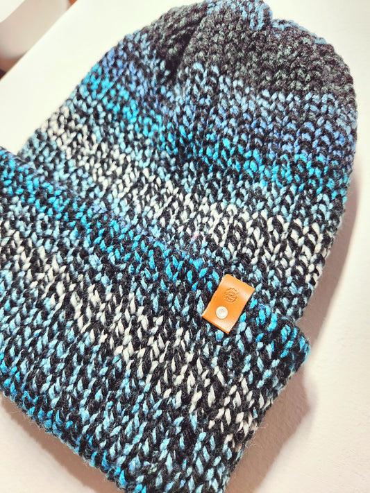 Knitted beanie with blue and black pattern on a white background