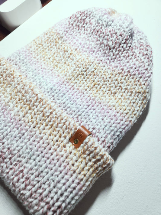 Knitted hat with a leather patch on a white surface