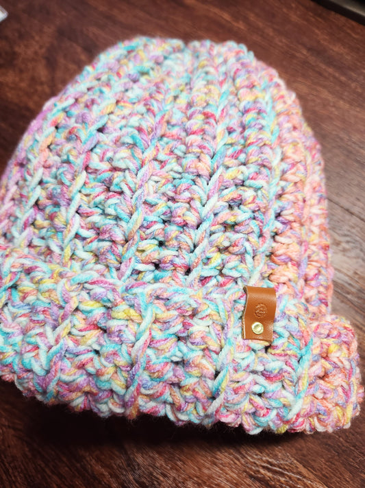Multicolored knitted beanie on a wooden surface