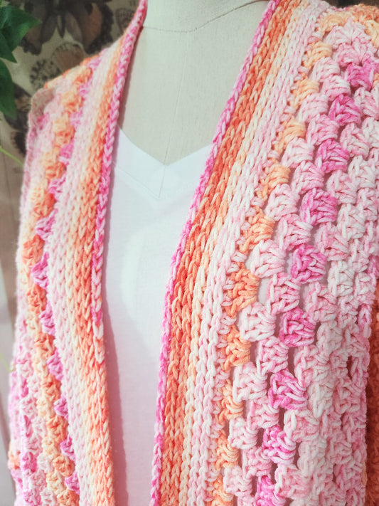 Mannequin wearing a pink and orange striped knitted cardigan.