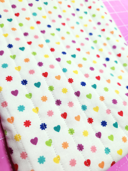 Colorful polka dot fabric on a pink cutting mat
