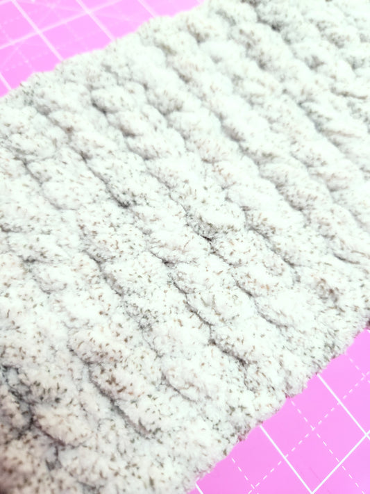 Close-up of textured fabric on a pink cutting mat