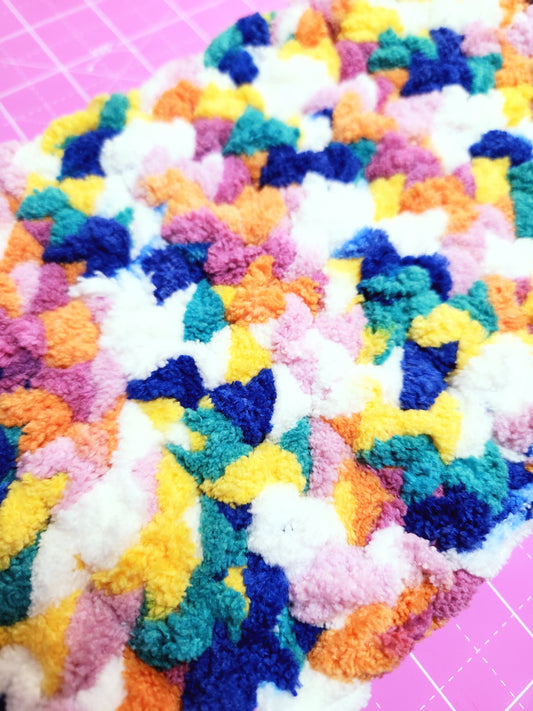 Multicolored textured fabric on a pink grid background