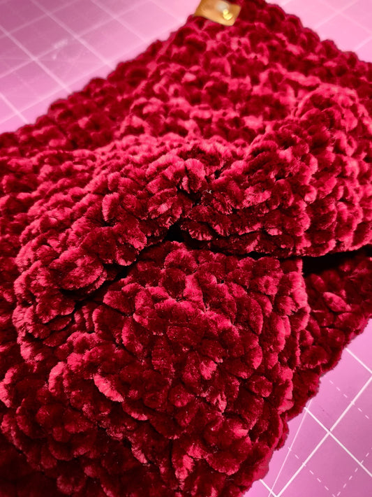 Close-up of a red textured fabric on a pink cutting mat