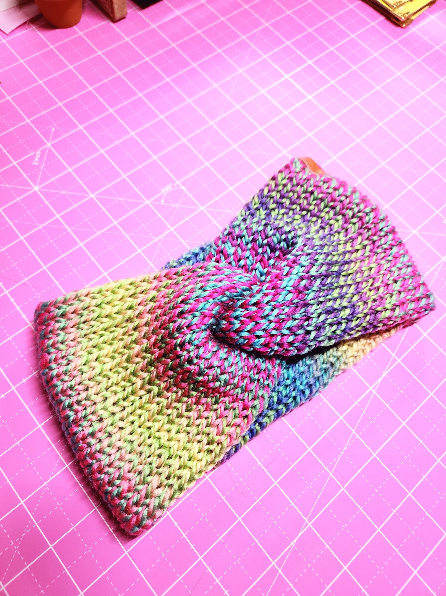 Multicolored knitted fabric on a pink grid background