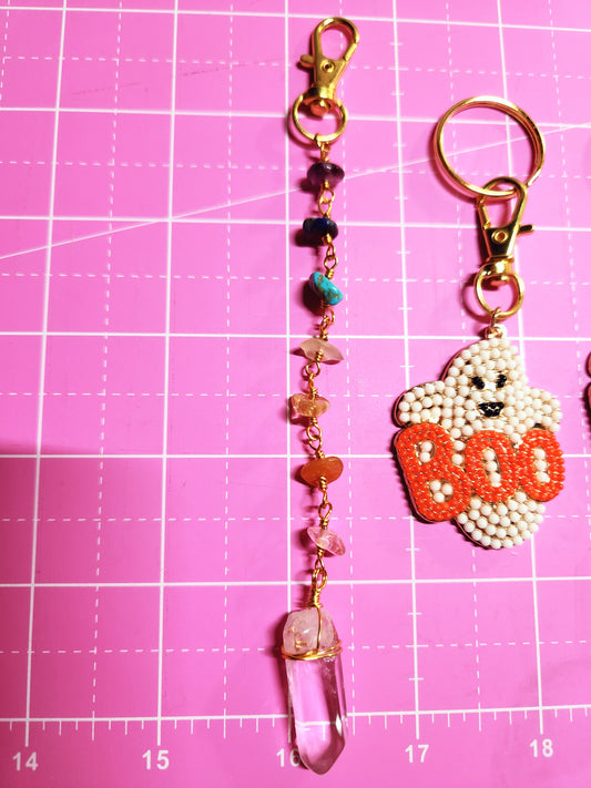 Decorative keychain with beads and charms on a pink cutting mat