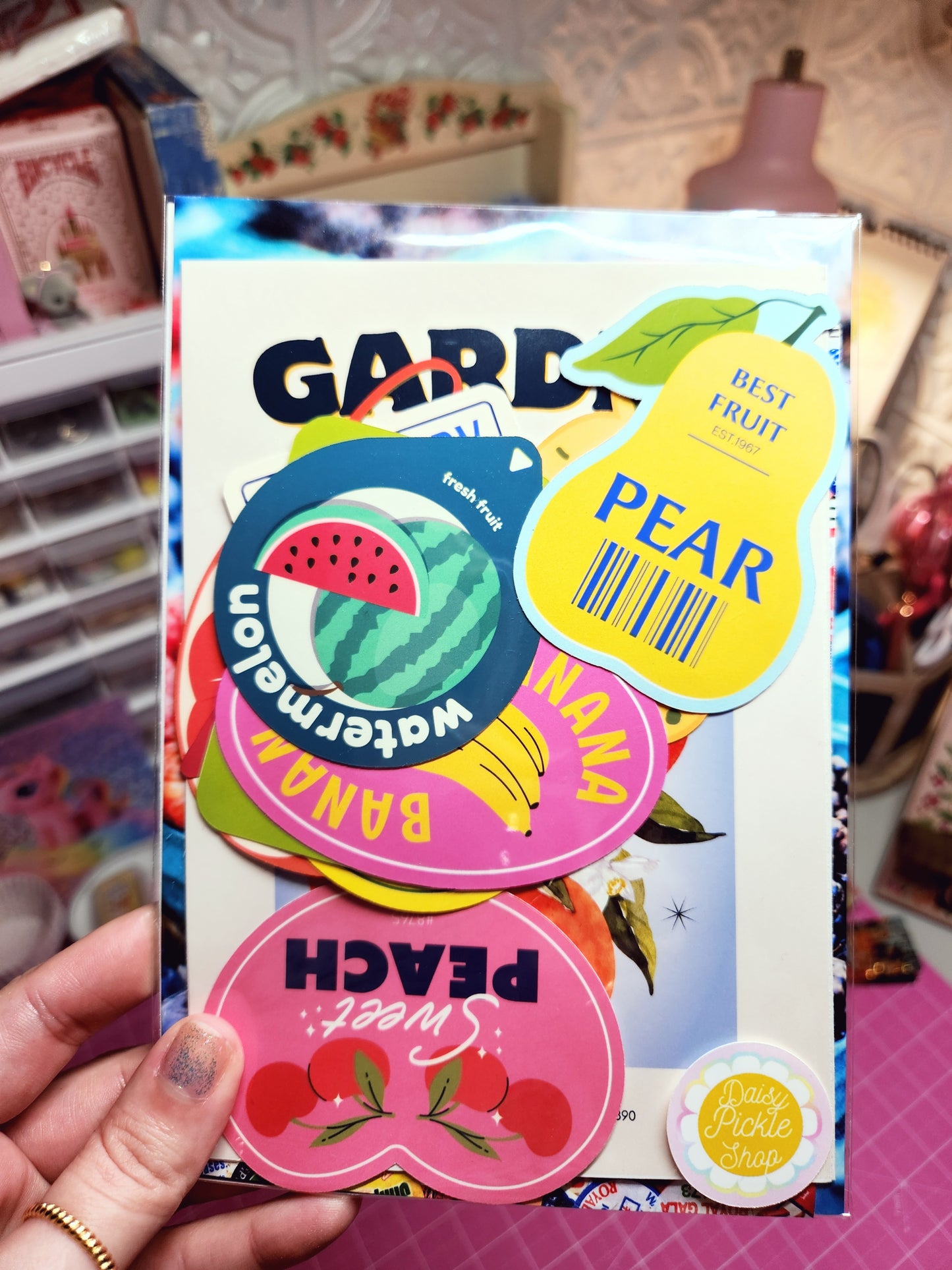 Colorful fruit-themed product packaging held by a person.