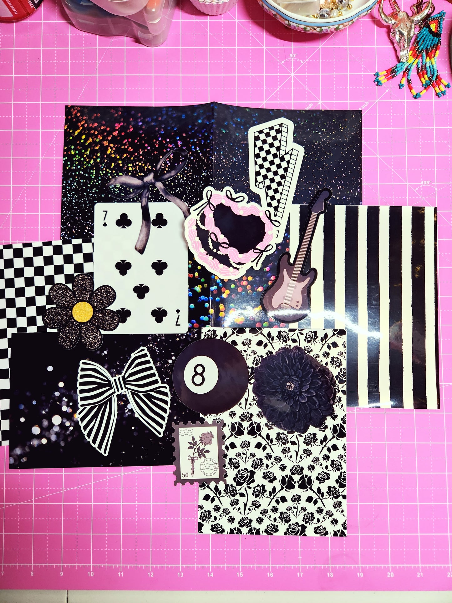 Collection of decorative paper pieces on a pink cutting mat with grid lines