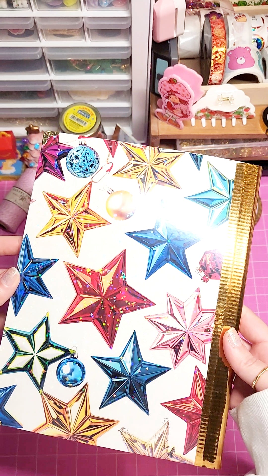 Colorful star-shaped stickers held over a crafting table with supplies.