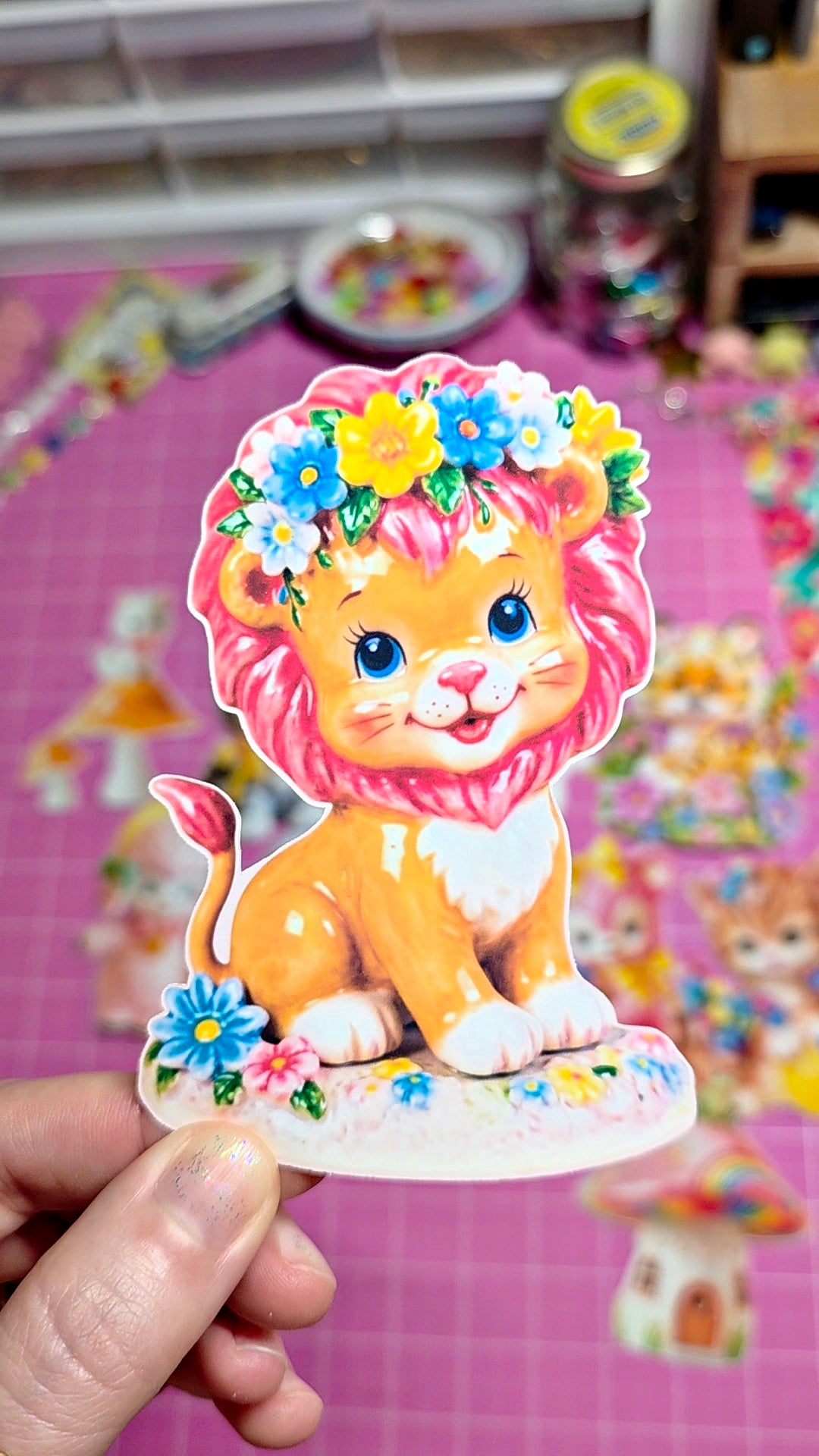 Cartoon lion with flowers held against a colorful background