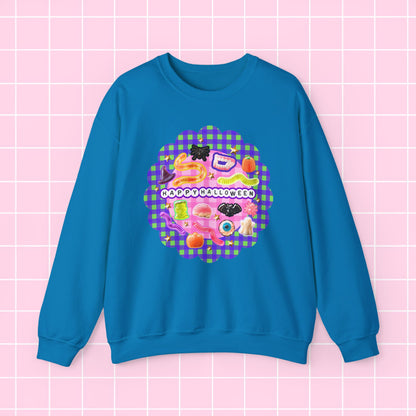 A bright blue crewneck sweatshirt featuring a colorful retro graphic with the text 'HAPPY BLESSING' and a pink gingham pattern, displayed on a pink grid background.