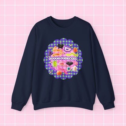 A navy blue crewneck sweatshirt featuring a colorful retro-style graphic on the chest with the text 'HAPPY BLESSING YOU' and a pink and purple gingham scalloped border, displayed against a pink grid background.
