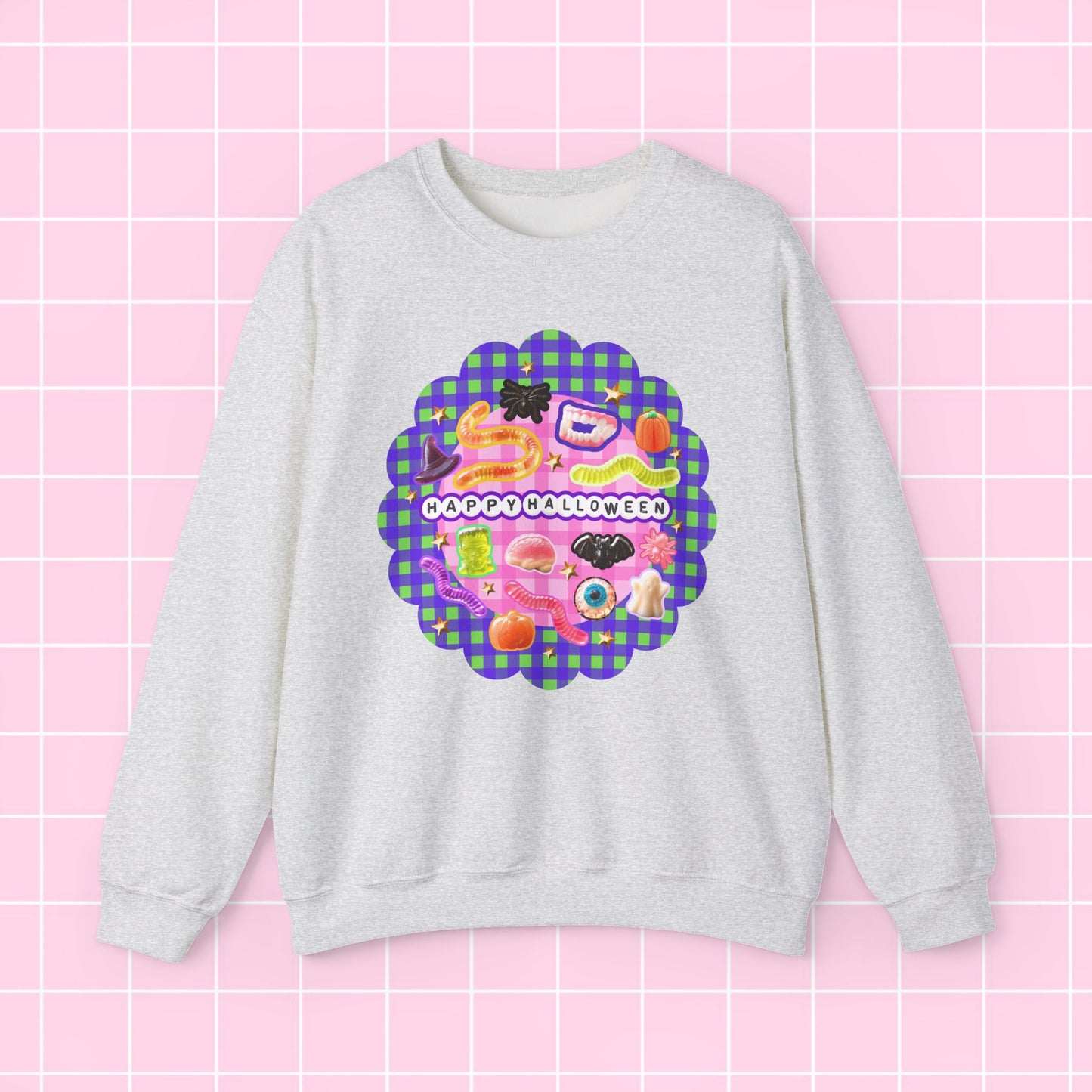 A light heather gray crewneck sweatshirt featuring a colorful retro graphic with the text 'HAPPY BIRTHDAY' on a pink and purple plaid scalloped background, displayed against a pink grid backdrop.