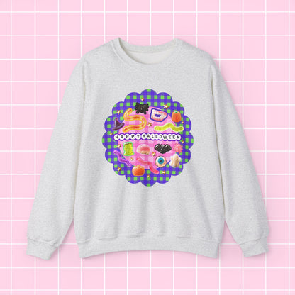 A light heather gray crewneck sweatshirt featuring a colorful retro graphic with the text 'HAPPY BIRTHDAY' on a pink and purple plaid scalloped background, displayed against a pink grid backdrop.