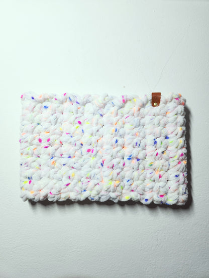 Textured white clutch with colorful speckles on a light gray background