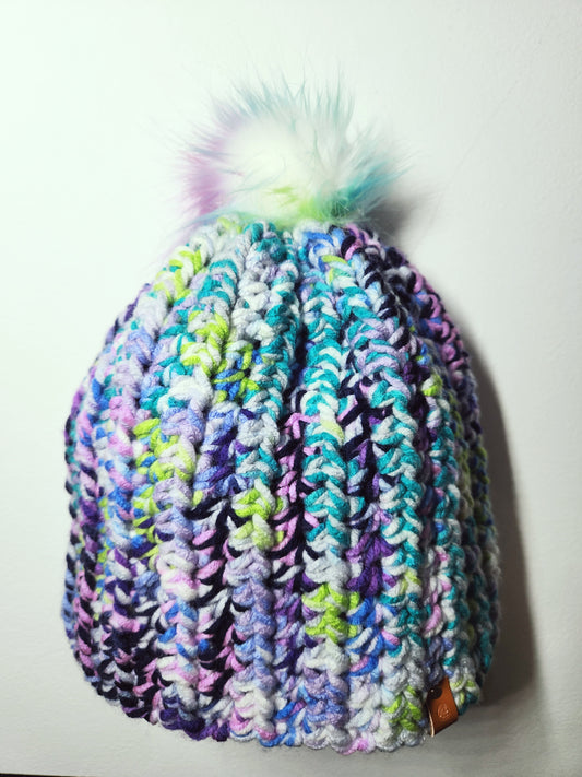 Multicolored knit beanie with a pom-pom on a white background