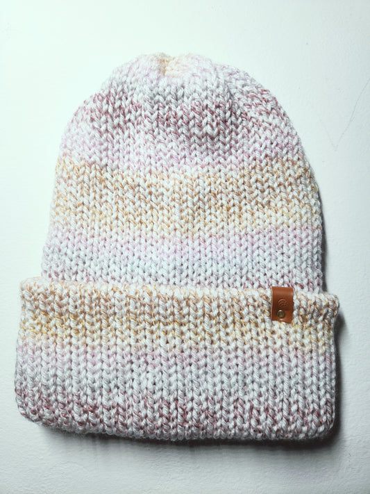 Knitted beanie with gradient color pattern on a light gray background