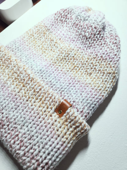 Knitted hat with a leather patch on a white surface