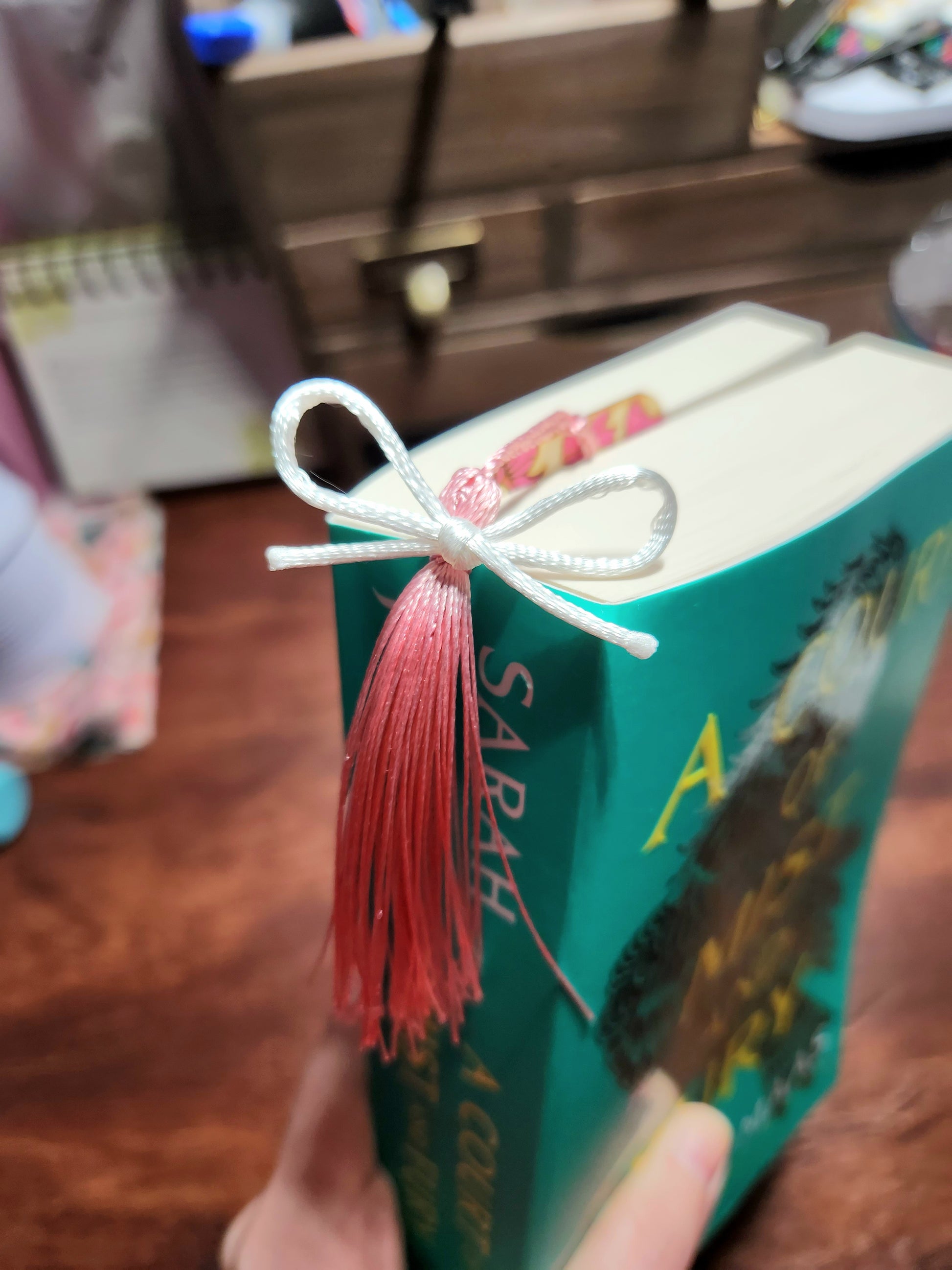 Book with a decorative tassel on a wooden surface