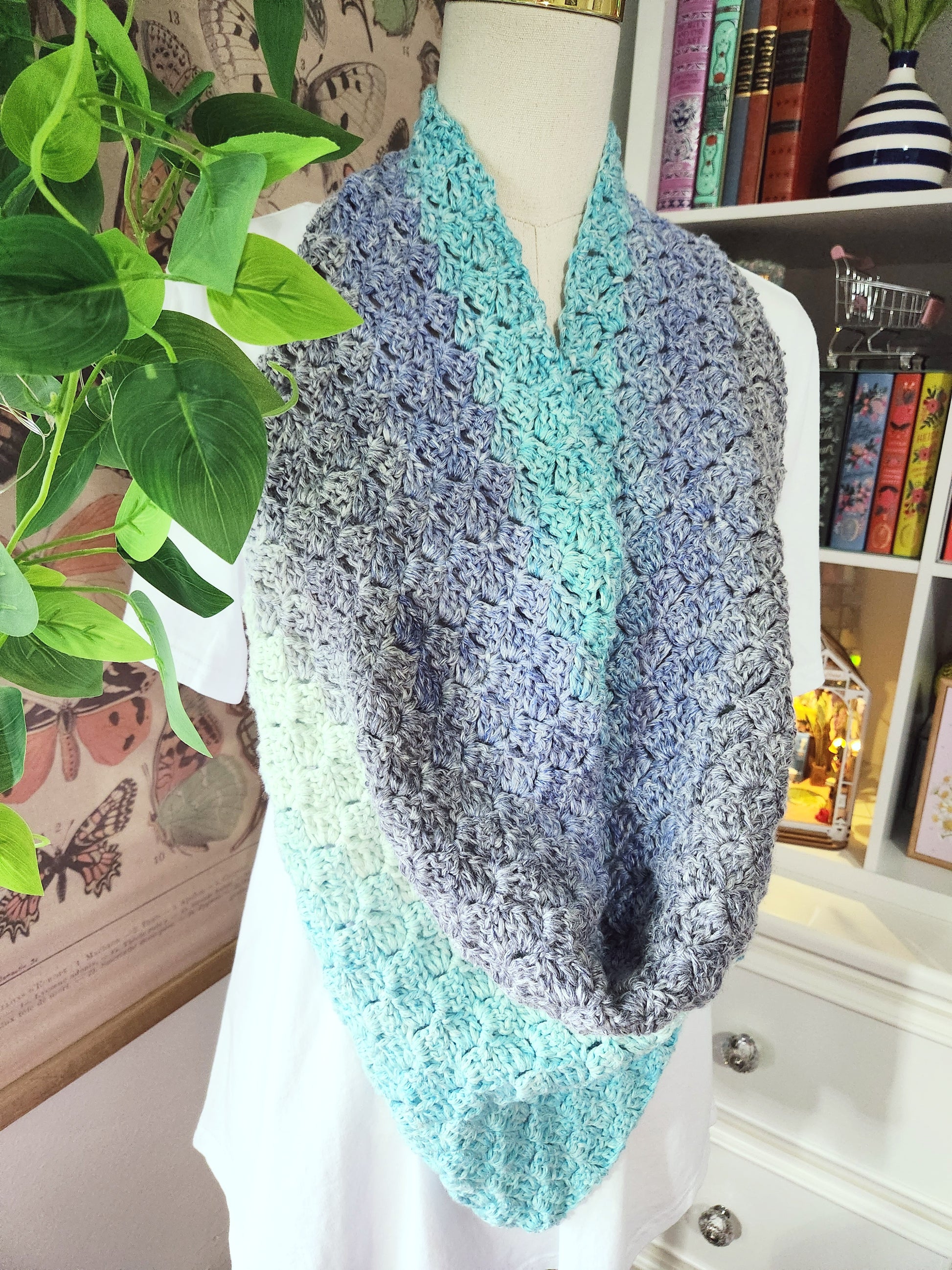 Knitted cowl with gradient color on a mannequin against a home decor background