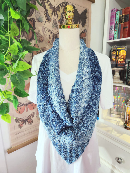 Blue patterned scarf on a mannequin with a decorative background