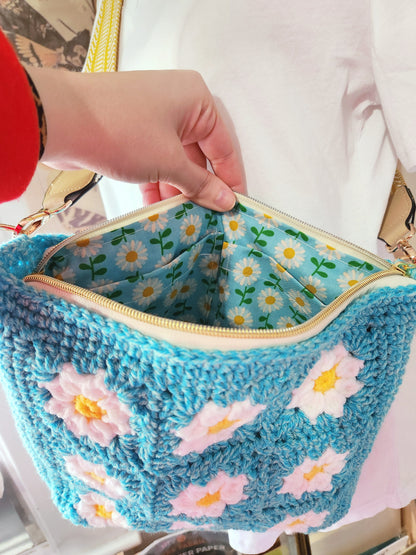 Blue woven bag with floral patterns on a white background