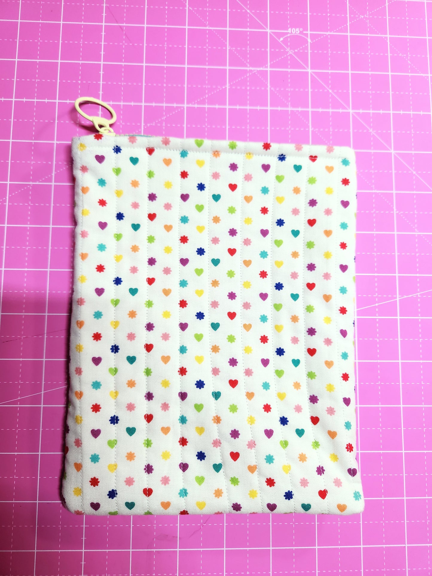 Fabric with colorful polka dot pattern on a pink grid background