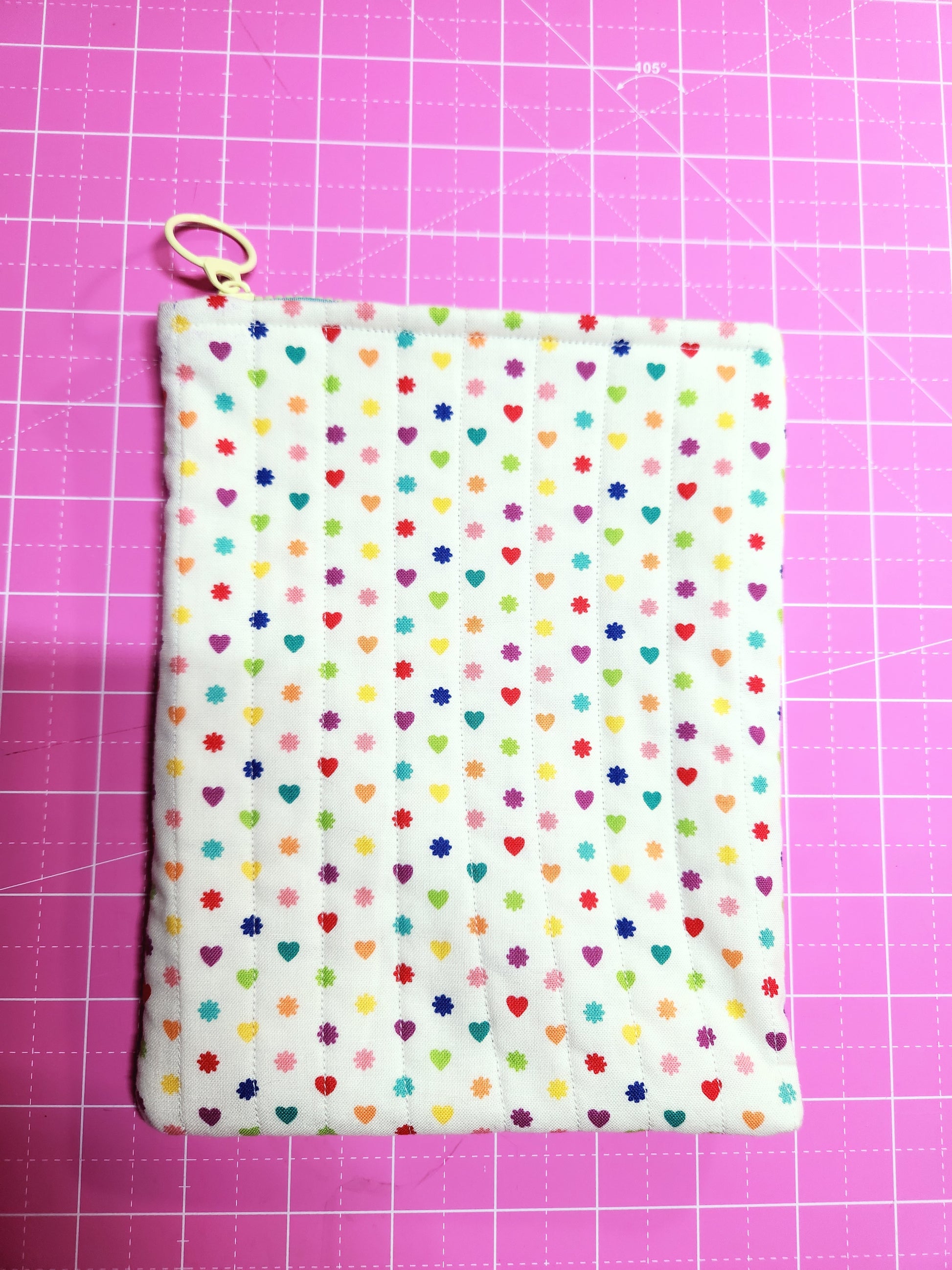 Fabric with colorful polka dot pattern on a pink grid background