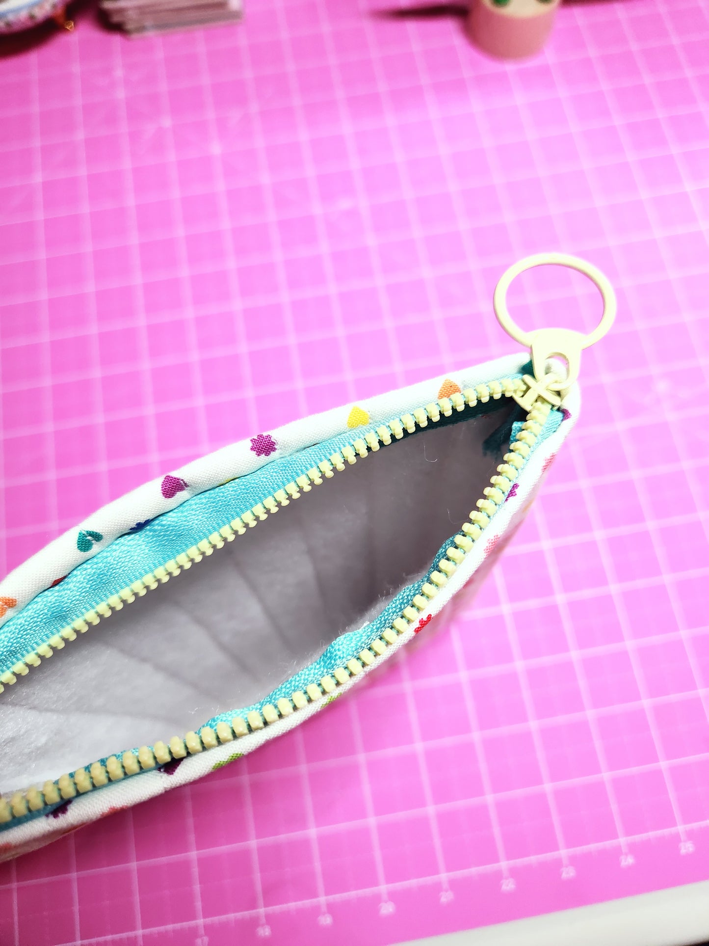 Pouch with colorful zipper on a pink grid background