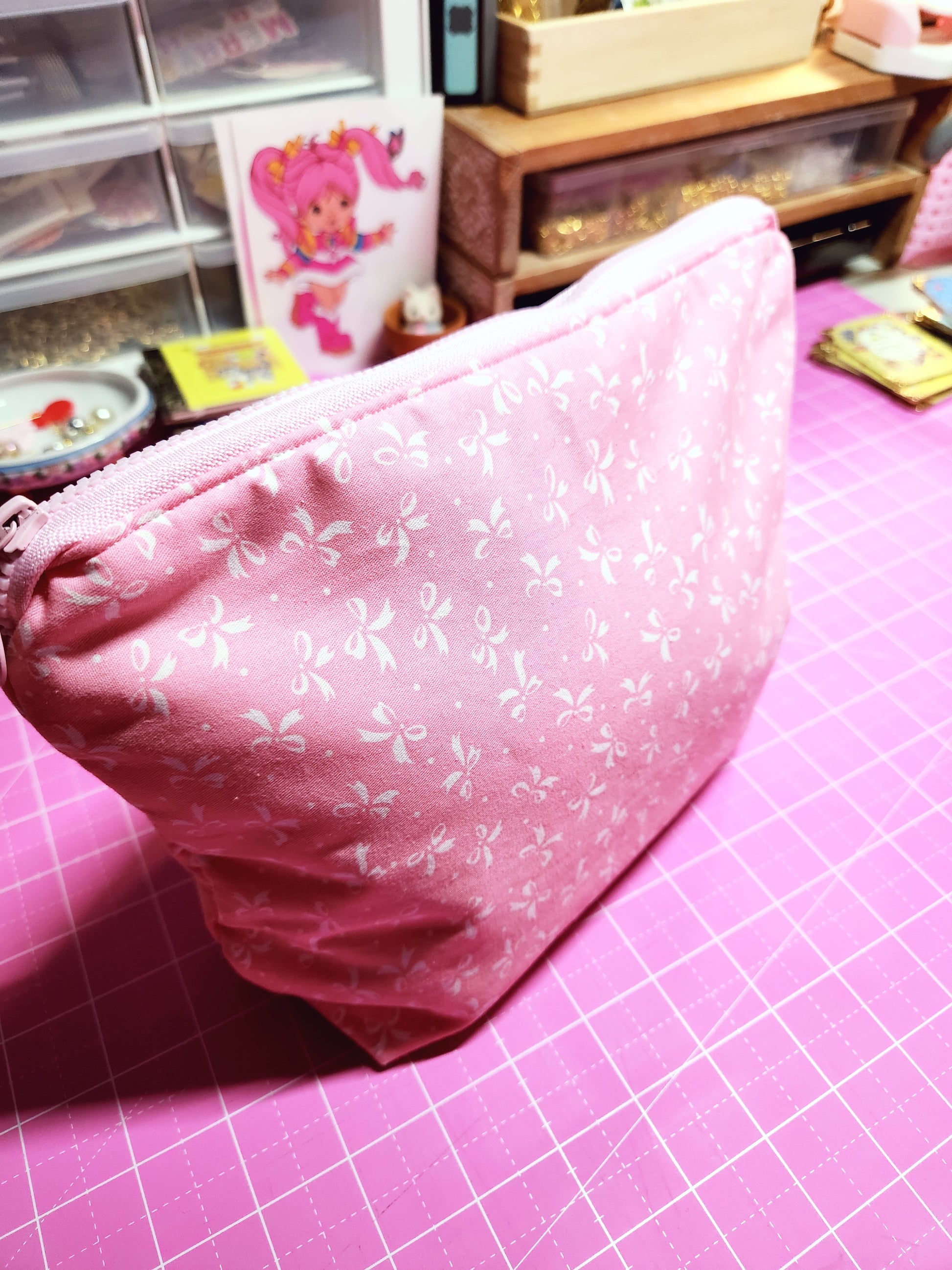 Pink fabric with white floral pattern on a pink grid background