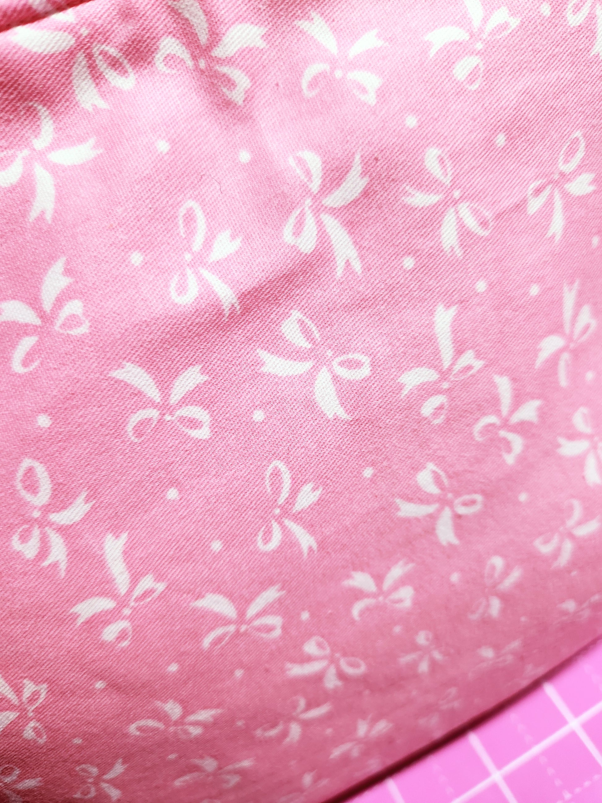 Pink fabric with white bow pattern
