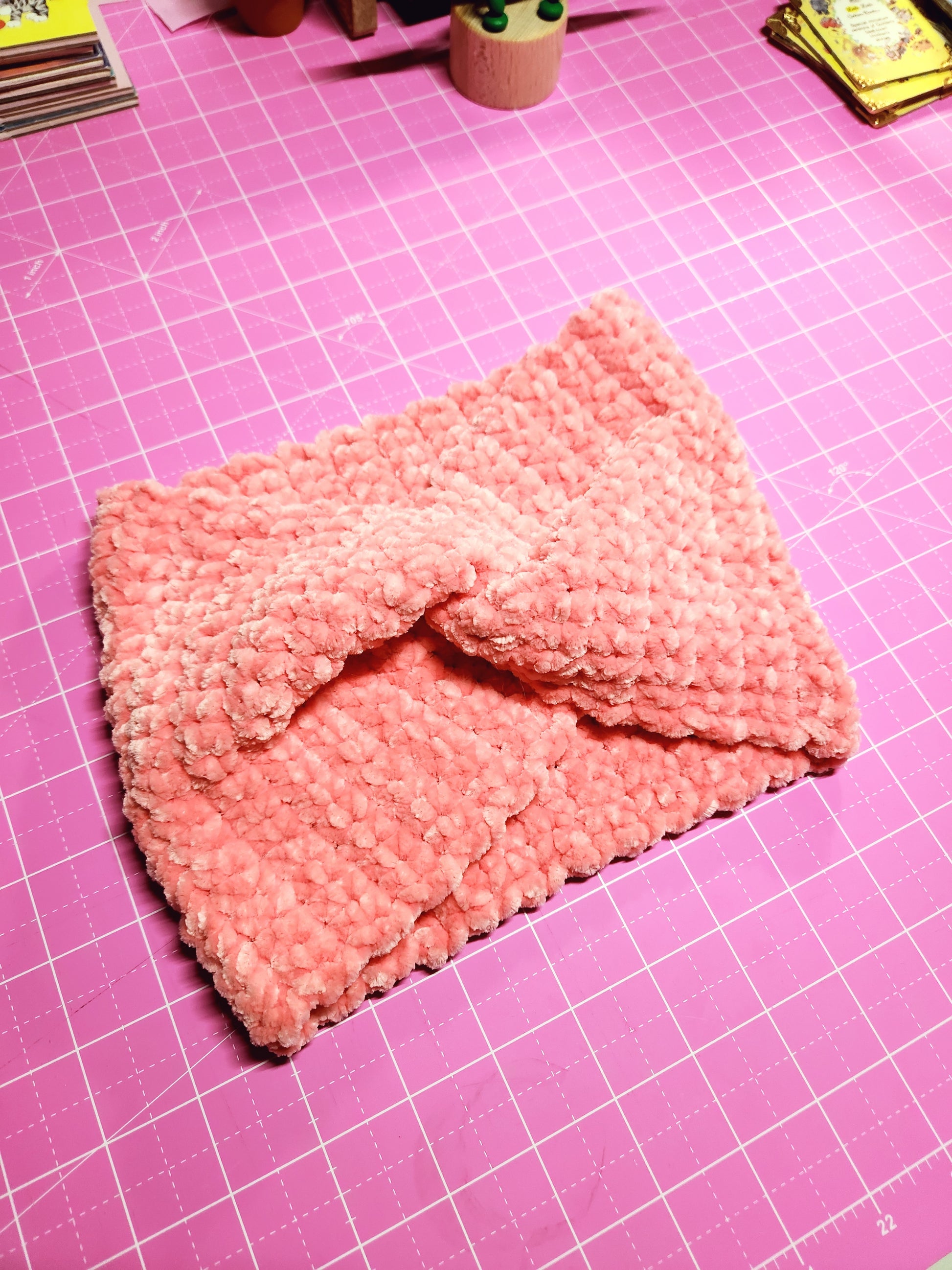 Pink knitted pouch on a pink grid background