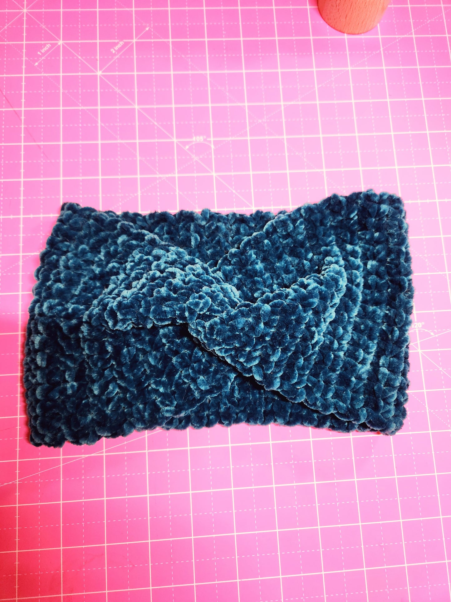 Blue knitted fabric on a pink grid background