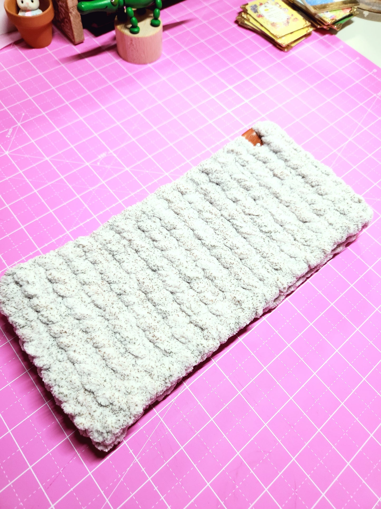 Textured rectangular object on a pink grid background