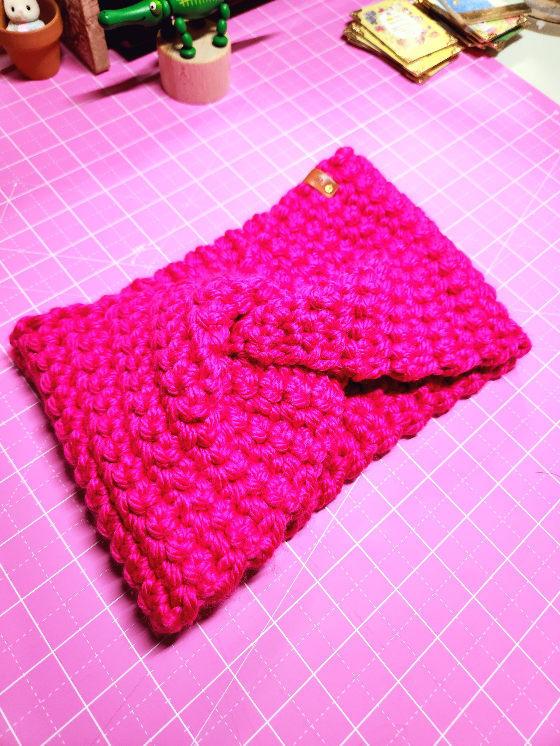 Pink knitted pouch on a pink grid background