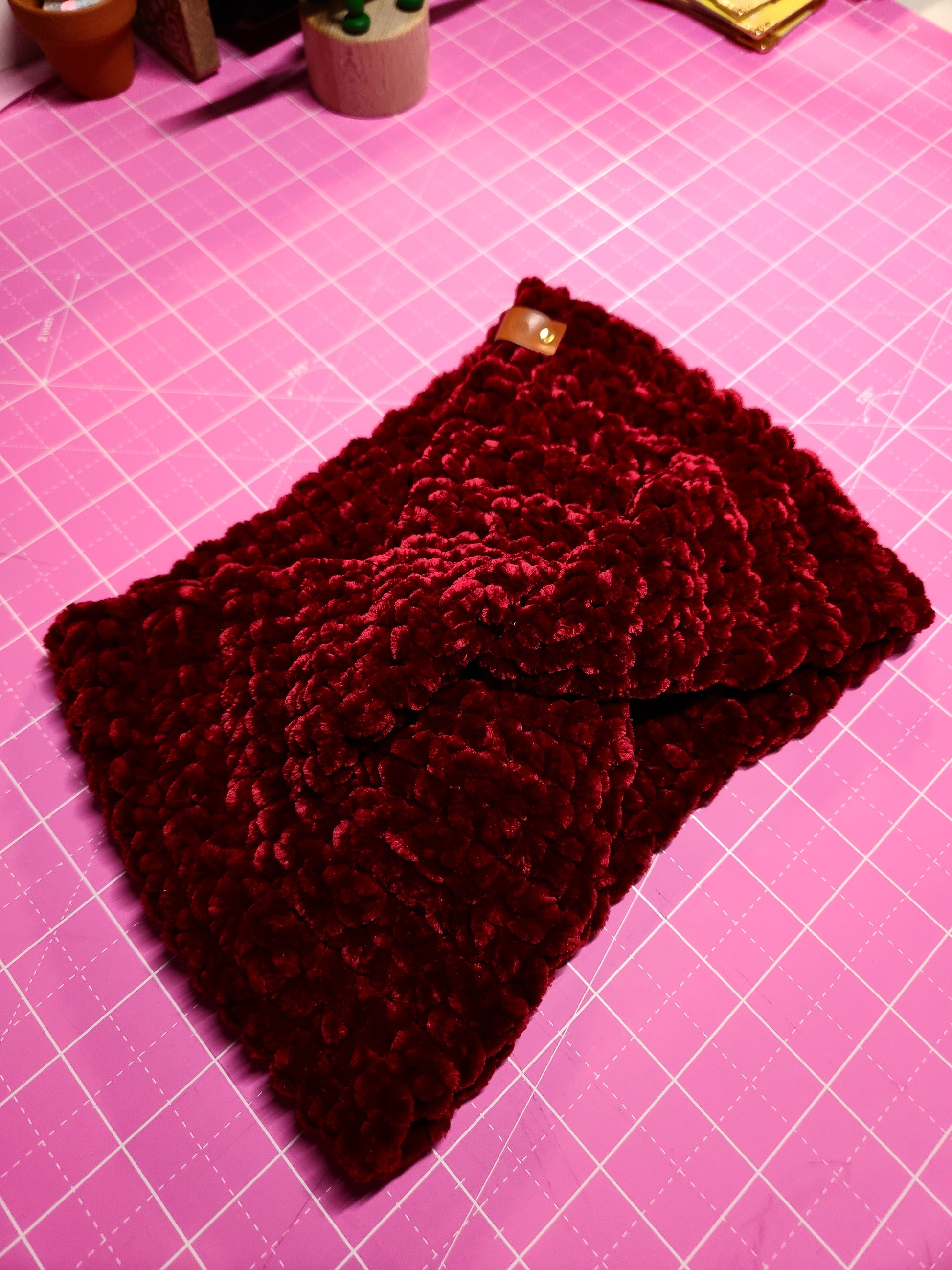 Knitted dark red fabric on a pink cutting mat