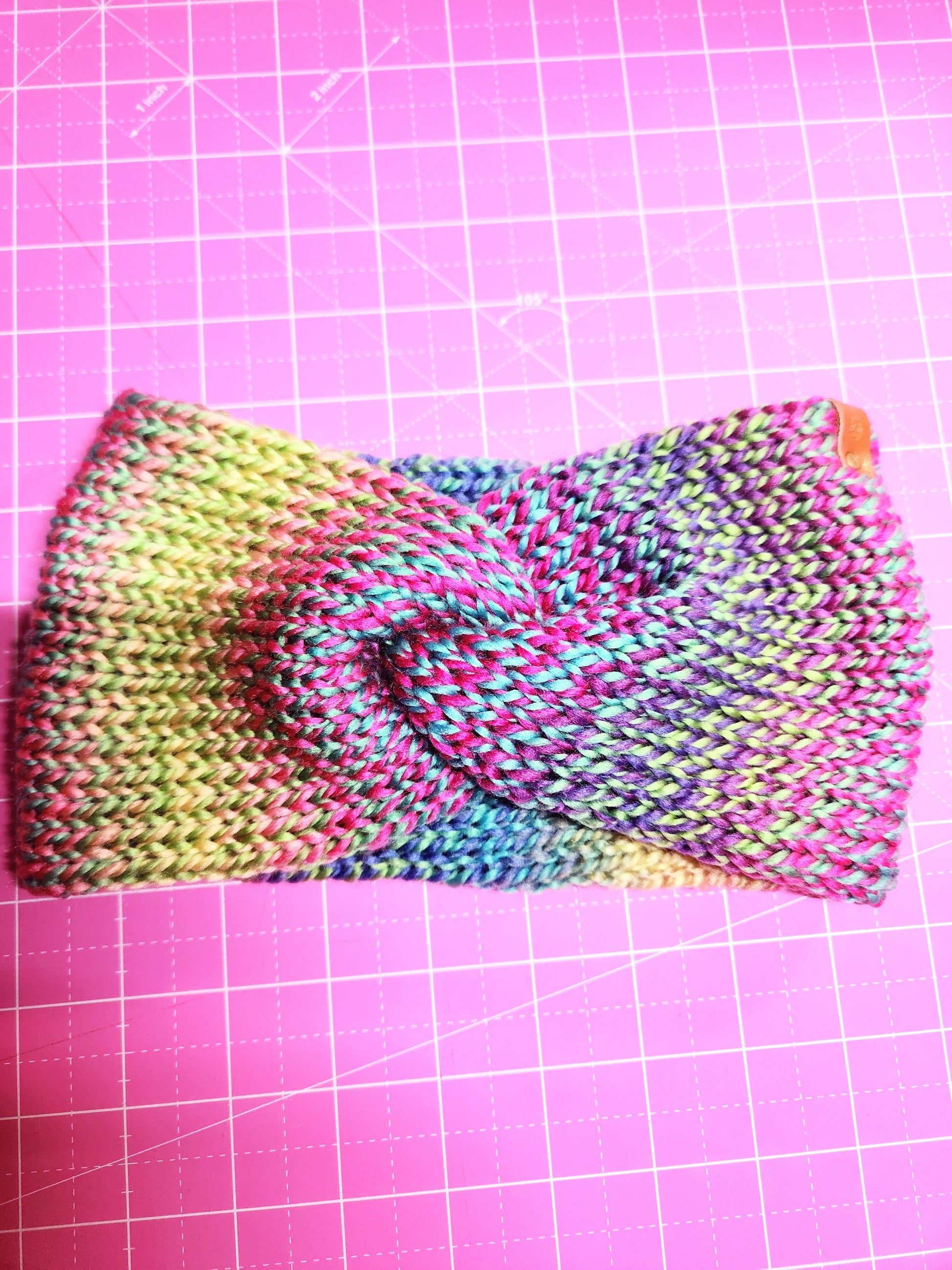 Colorful knitted fabric on a pink grid background
