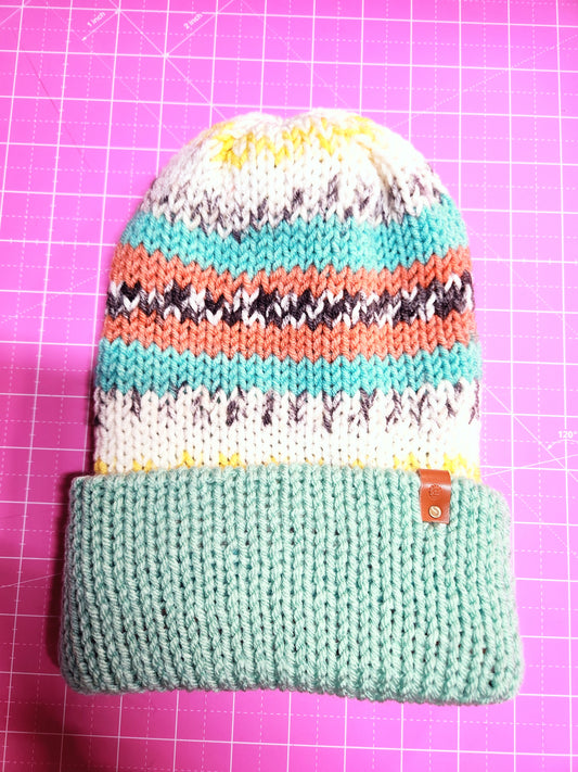 Knitted pouch with colorful stripes on a pink grid background