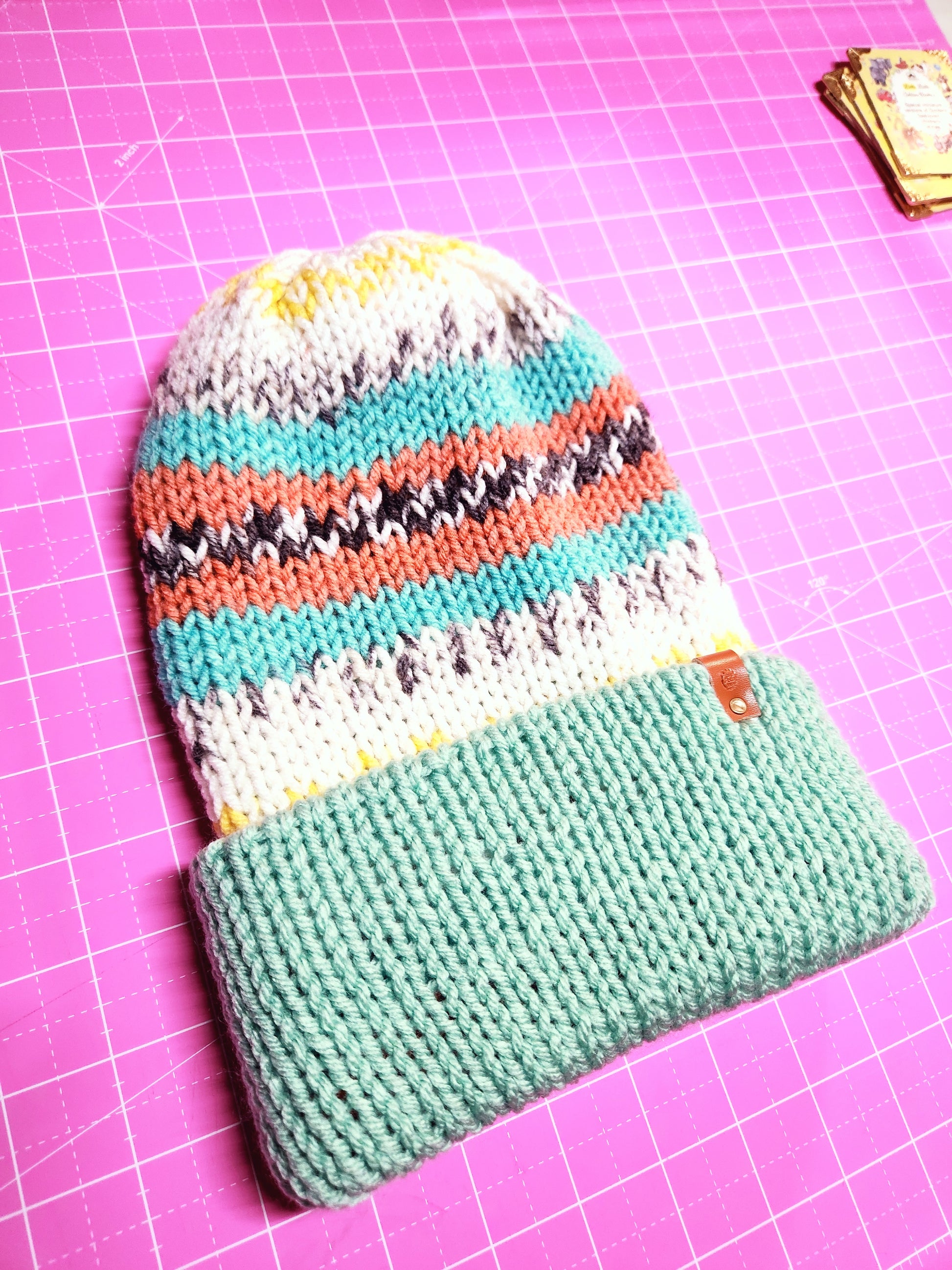 Two knitted pouches on a pink grid background