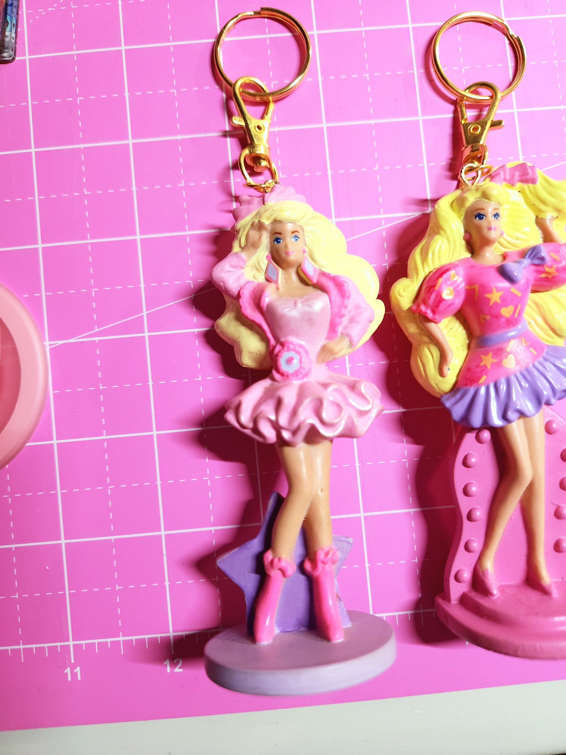 Barbie-themed keychains on a pink cutting mat