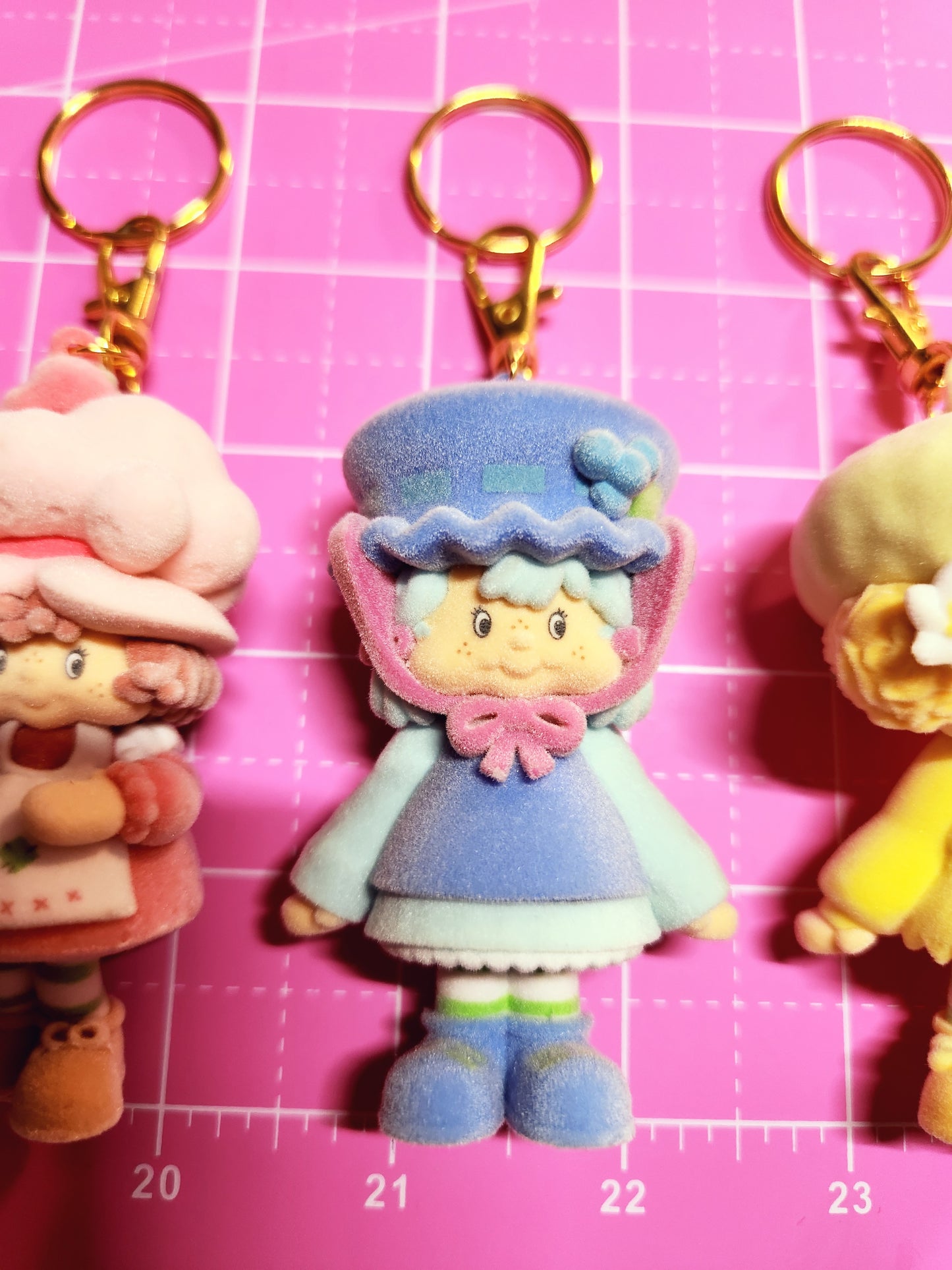 Colorful keychain with a character on a pink grid background