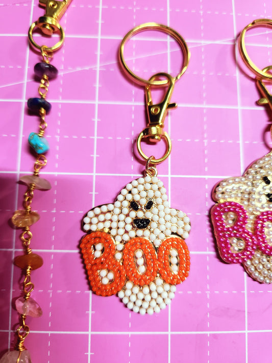 Decorative keychain with beads on a pink grid background