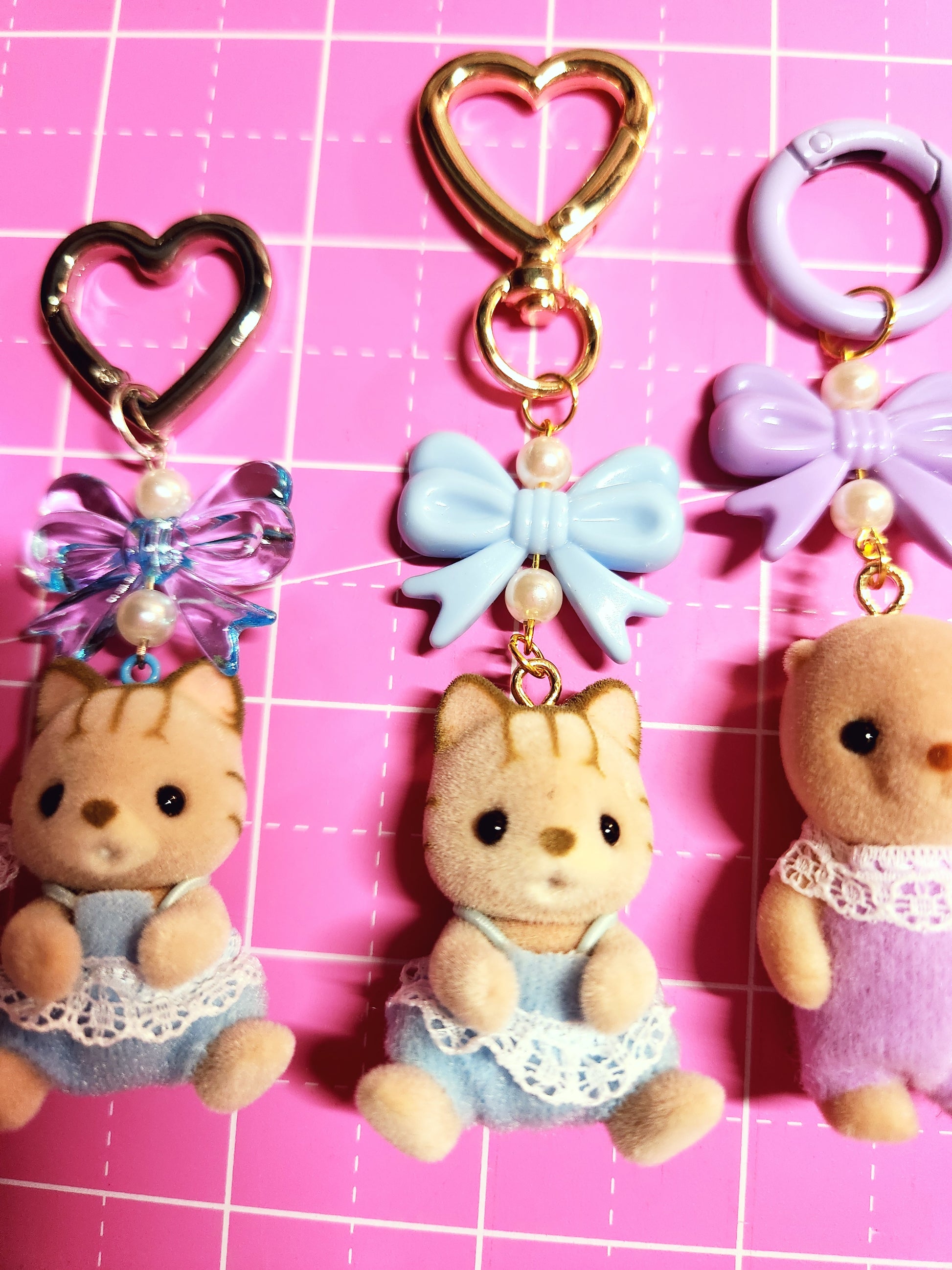 Keychains with cartoon character design on a pink grid background