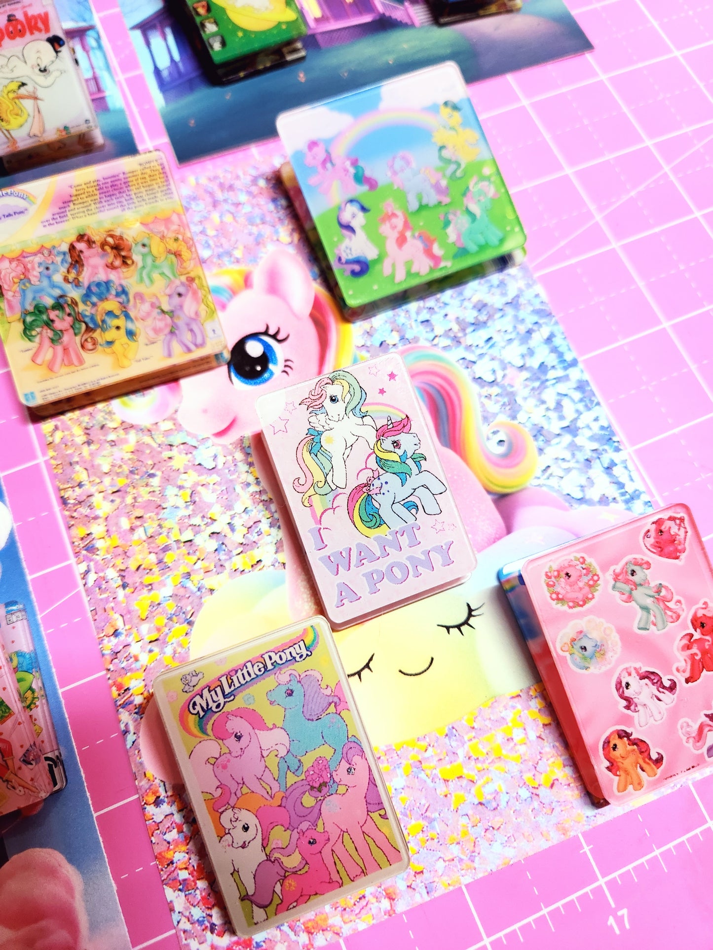 Colorful stationery items including notebooks and stickers on a pink grid background