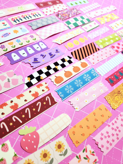 Collection of colorful washi tape rolls on a pink background