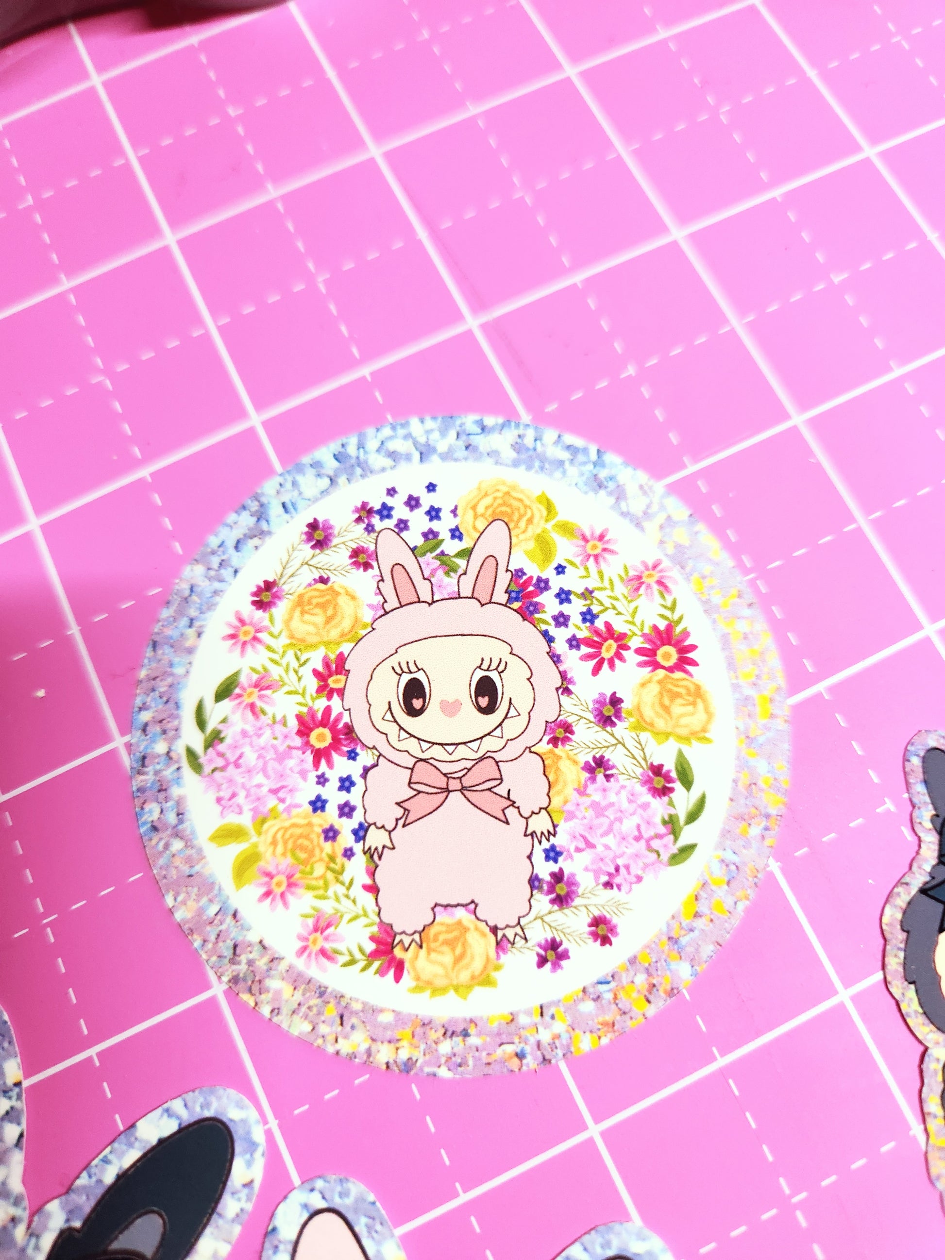 Decorative sticker with cartoon character and flowers on a pink grid background