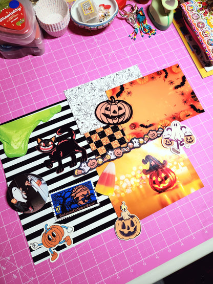 Halloween-themed decorative paper with pumpkins and ghosts on a pink cutting mat.